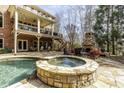 This backyard has a stone hot tub and in-ground pool, with an outdoor fireplace and balcony at 5284 Vernon Springs Trl, Sandy Springs, GA 30327