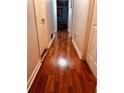 Hallway featuring gleaming wood floors and white trim, leading to multiple rooms at 10143 Settlers Grove Ne Rd, Covington, GA 30014