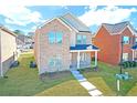 Charming two-story brick home with a manicured lawn and inviting front porch at 653 Armitage Way, Stockbridge, GA 30281