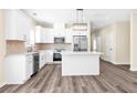 Bright kitchen featuring white cabinetry, stainless steel appliances, and center island at 653 Armitage Way, Stockbridge, GA 30281