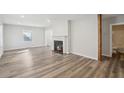 Bright living room featuring new floors, fireplace, and fresh white paint at 1694 Kenmore Sw St, Atlanta, GA 30311