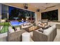 Stylish outdoor seating area with a stone fireplace, grill, ceiling fan, and a view of the pool at 3451 Paces Valley Nw Rd, Atlanta, GA 30327