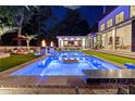 Beautiful backyard pool and outdoor living area with lounge seating, umbrellas, and fire pits at dusk at 3451 Paces Valley Nw Rd, Atlanta, GA 30327