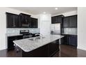 Modern kitchen features dark cabinets, stainless steel appliances and granite countertops at 813 Whittington Sw Pkwy, Marietta, GA 30060
