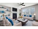 Staged living room featuring plush seating, fireplace, modern ceiling fan, and bright windows at 813 Whittington Sw Pkwy, Marietta, GA 30060