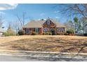 Inviting brick home with a well-maintained lawn and attractive curb appeal on a sunny day at 3999 Treemont Ln, Suwanee, GA 30024