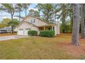 Traditional two-story home with a two-car garage and a cozy front porch, surrounded by a lush, green lawn at 5065 Hubert Dr, Powder Springs, GA 30127