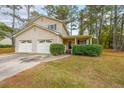 Charming two-story home featuring a two-car garage and a cozy front porch nestled among mature trees at 5065 Hubert Dr, Powder Springs, GA 30127