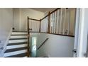 Inviting entryway showcasing stairs with white risers and wood railing leading to the second floor at 893 Boca Raton Dr, Forest Park, GA 30297