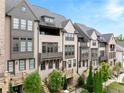An eye-level side view showcases the townhome's architecture, and beautiful landscaping adds to the curb appeal at 6657 Encore Blvd, Atlanta, GA 30328