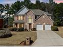 Charming two-story brick home featuring a manicured lawn and attached two-car garage at 6068 Magnolia Rdg, Stone Mountain, GA 30087