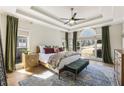 Serene main bedroom features tray ceilings, a ceiling fan, and ample natural light at 3825 Bishops Walk, Cumming, GA 30041