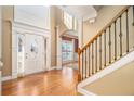 Bright foyer with hardwood floors, staircase, and decorative glass front door at 145 Windward Hls, Mcdonough, GA 30253