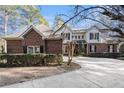 Charming brick and siding home with mature landscaping, a circular driveway, and shuttered windows at 5930 N Eton Ct, Duluth, GA 30097