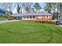 Charming home with a well-manicured lawn and a covered front porch at 2021 Windsor Ln, Snellville, GA 30078