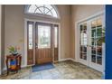 Inviting home foyer showcases tile flooring, a decorative front door, and bright natural lighting, and double french doors at 9235 Heatherton Walk, Duluth, GA 30097