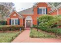 Inviting red brick home with a welcoming front walkway and manicured bushes at 9235 Heatherton Walk, Duluth, GA 30097