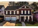 Lovely red brick two-story home featuring a covered porch, black shutters, and an attached two-car garage at 1545 Heritage Trl, Roswell, GA 30075