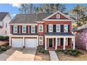 Beautiful two-story red brick home featuring black shutters, a covered porch, and manicured landscaping at 1545 Heritage Trl, Roswell, GA 30075