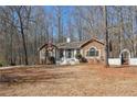 View of a stone accented home with a welcoming front yard and charming white picket fence and arbor at 332 Stonecutters Cv, Stockbridge, GA 30281