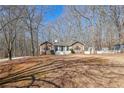 View of the exterior of a stone accented home with a nice front yard surrounded by trees at 332 Stonecutters Cv, Stockbridge, GA 30281