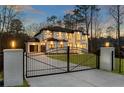 Elegant two-story home with modern design, black framed windows, gated entry and professional landscaping at 5238 Timber Ridge Rd, Marietta, GA 30068