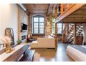 Open living area features exposed brick, a fireplace, wood beams, and modern decor with natural light at 170 Boulevard Se # 111H, Atlanta, GA 30312