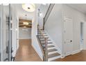 Inviting home entryway with hardwood floors, stairs with black iron railing, and an open view to the living area at 320 Gray Shingle Ln, Woodstock, GA 30189