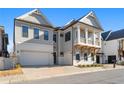 Beautiful two-story home featuring a brick driveway, covered porch, attached garage, and professionally landscaped front yard at 320 Gray Shingle Ln, Woodstock, GA 30189