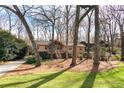 Beautiful home with a mix of stone and wood facade surrounded by lush trees and a well-maintained lawn at 3640 Shelby Ln, Marietta, GA 30062