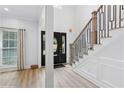 Bright entryway featuring hardwood floors, black door, modern staircase, and ample natural light at 5273 Glenridge Dr # 5273, Sandy Springs, GA 30342