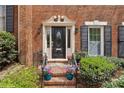 Elegant brick home entrance with decorative door surround and well-manicured landscaping at 5273 Glenridge Dr # 5273, Sandy Springs, GA 30342