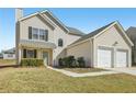 Traditional-style home with a two-car garage, well-manicured lawn, and inviting front entrance at 7282 Williamsburg Dr, Riverdale, GA 30274
