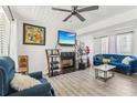 Cozy living room with a fireplace, ceiling fan, and comfortable seating at 7282 Williamsburg Dr, Riverdale, GA 30274