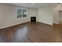 Spacious living room with a fireplace, large windows for ample natural light, and sleek hardwood flooring at 8120 Berrywood Ct, Covington, GA 30014