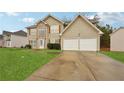 Traditional two-story house featuring a two-car garage, symmetrical design, and inviting curb appeal in a suburban setting at 3308 Hunting Creek Pass, Douglasville, GA 30135