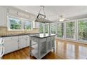 Bright kitchen with a central island, hardwood floors, and large windows overlooking the yard at 5445 Mountain Trl, Douglasville, GA 30135