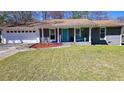 Charming single-story home featuring a manicured lawn, painted brick, and a delightful covered front porch at 6451 Katherine St, Douglasville, GA 30134