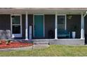 Inviting front porch featuring gray painted brick, colorful door, and bench seating for relaxation at 6451 Katherine St, Douglasville, GA 30134