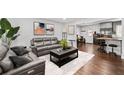 Inviting living room featuring hardwood floors, comfortable leather seating, and an open layout to the dining area at 6451 Katherine St, Douglasville, GA 30134