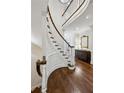 Elegant curved staircase with hardwood floors and white railings at 3114 Peachtree Ne Dr, Atlanta, GA 30305