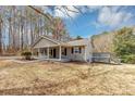 Side view of a single-story home featuring gray siding, a deck, and a spacious, unfenced yard at 4251 Klondike Rd, Lithonia, GA 30038