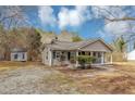 Single-story home featuring a covered front porch, gray siding, an outbuilding, and a spacious yard at 4251 Klondike Rd, Lithonia, GA 30038