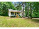 Quaint one-story house with inviting front porch and lush greenery at 7281 Fernwood Dr, Riverdale, GA 30296