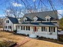 Charming two-story home with a inviting front porch, red door, and manicured lawn at H-5422 Hill Sw Rd, Powder Springs, GA 30127