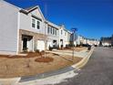 Street view of townhouses, sidewalks, and manicured lawns under a blue sky at 3568 Eagle Sw Ct, Atlanta, GA 30331