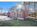 Quaint brick home featuring a lush, green yard with mature trees and natural light at 4809 Lavista Rd, Tucker, GA 30084