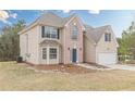 Traditional two-story home features a brick facade with a well-maintained front lawn and two-car garage at 2724 Kristen Ct, Conyers, GA 30012