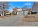 Well-manicured lawn showcasing a traditional-style home with a brick and siding exterior and driveway at 203 Roseman Way, Woodstock, GA 30188