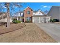 Attractive two-story home with brick and siding, set on a well-maintained lawn and driveway at 203 Roseman Way, Woodstock, GA 30188